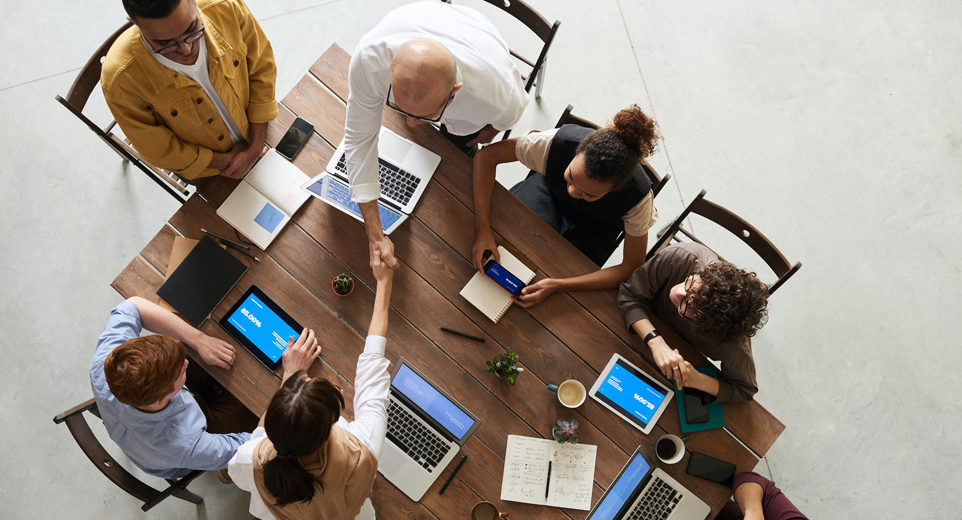 a group of people sitting at a table with a laptop